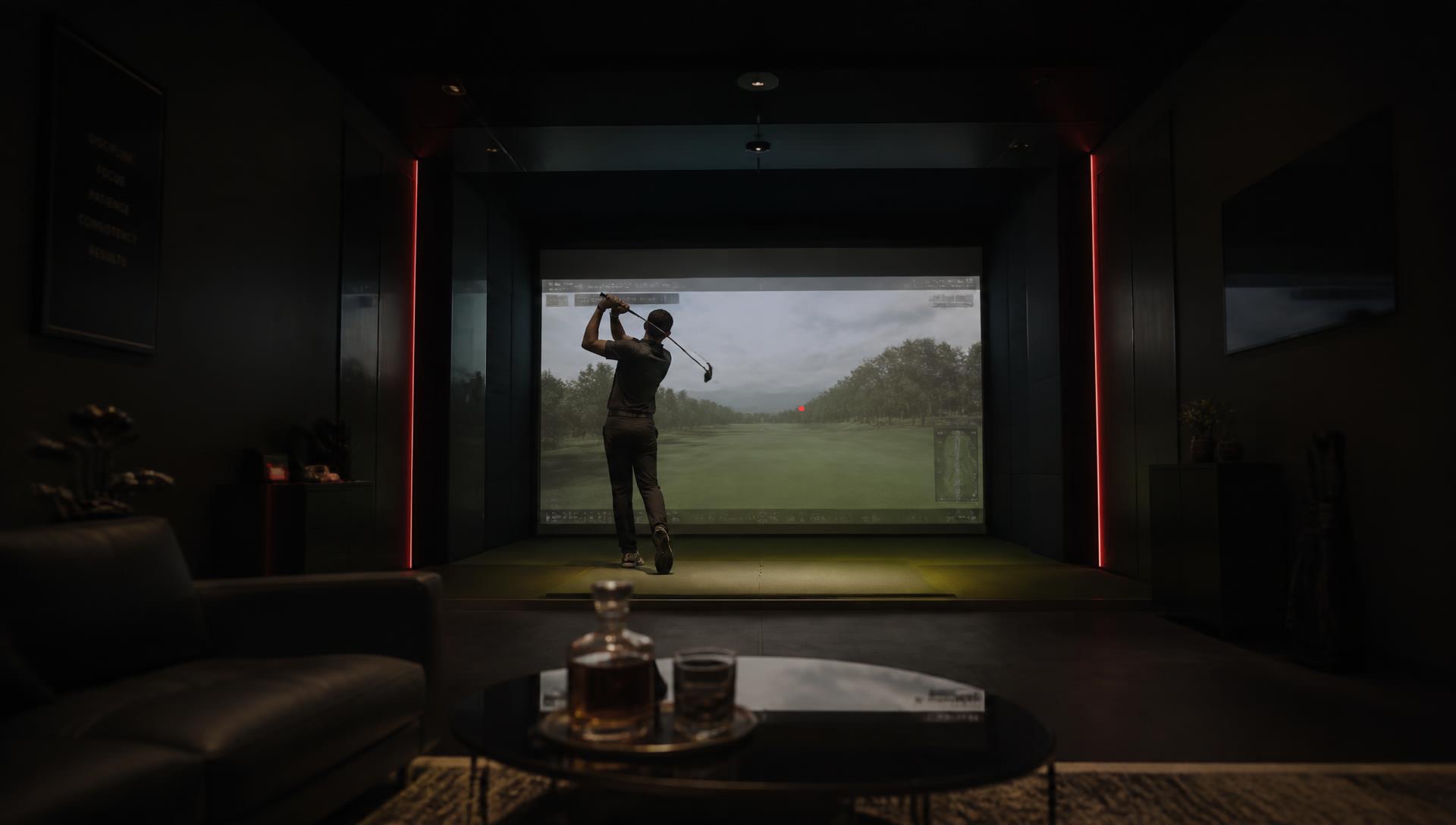 Golfer mid-swing inside a premium golf simulator bay